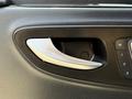 Close-up of the door handle of a 2019 Mercedes-Benz Sprinter featuring a sleek silver design and integrated controls