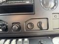 Dashboard controls of a 2010 Ford Econoline featuring audio controls and several knobs and buttons for various functions