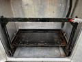 A black metal frame with a flat base and vertical supports designed for holding items in a storage compartment of a vehicle