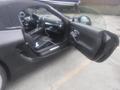 A black 2016 Porsche Boxster with an open driver's door and a partially visible interior