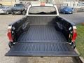 A 2013 Toyota Tacoma truck bed with a black lined interior and open tailgate showcasing the cargo area