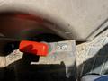A red lever on a control panel with an engraved illustration indicating its function on a Kubota M8540D tractor