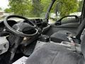 Interior of a 2014 Hino 195 truck showing the driver's seat steering wheel and dashboard with controls and a gear shifter