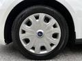 Close-up of a silver wheel with a distinct multi-spoke design mounted on a black tire featuring traction patterns