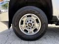A close-up of a chrome wheel rim on a 2016 Chevrolet Silverado 2500HD with a Goodyear Wrangler tire