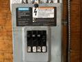 A Siemens EQ Loadcentre with multiple circuit breakers and a warning label, mounted on a surface with wires connected