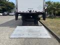 A 2015 Freightliner M2 106 truck with a lowered liftgate positioned at the rear for loading and unloading cargo