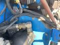 Close-up of a 1997 Genie S-65 4X4 showing hydraulic hoses connectors and electrical components in a blue metal housing