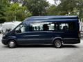 A blue 2017 Ford Transit 350 van with multiple side windows and a high roof design parked on a flat surface