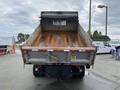 A 2011 Dodge Ram 5500 flatbed truck with a dump bed raised revealing a rusted interior