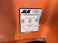 A close-up of a weathered label from a 2012 JLG E400AJFN showing patent information and the company's name JLG Industries Inc