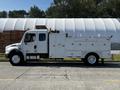 A white 2004 Freightliner M2 truck with a service body featuring multiple compartments and tools mounted on the roof