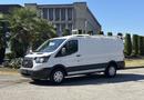 A white 2016 Ford Transit van parked with a smooth exterior and distinctive front grille