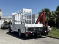 A 2013 Ford F-550 with a flatbed and a mounted crane in the back