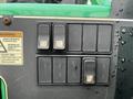 Control panel of a 2014 JLG 10054 featuring several switches and a warning label about safety precautions while operating the machine
