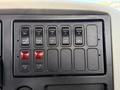 A control panel featuring multiple switches and buttons labeled for various functions like PTO, strobe light, and boom operations in a 2011 International 7500 vehicle