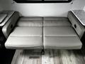 A grey leather sofa bed designed for a recreational vehicle with a clean, modern look and comfortable seating arrangement