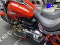 A 2024 Harley Davidson Fat Boy motorcycle in red with chrome details and a black seat featuring red stitching