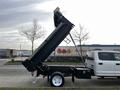 A 2021 Ford F-550 with a raised dump bed positioned for unloading materials