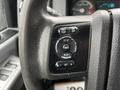 Close-up of the control panel on the steering wheel of a 2014 Ford F-550 featuring buttons for setup info and reset