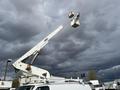 A 2008 Ford Econoline with a raised aerial lift arm and a bucket at the top