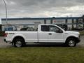 A 2016 Ford F-150 truck in white with a regular cab and four-wheel drive badge on the side