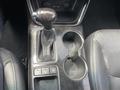 Interior of a 2015 Kia Sorento showing the gear shift lever cup holders and control buttons on the center console