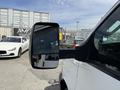 A 2017 Chevrolet Express van with a large side mirror reflecting part of the vehicle and a glimpse of nearby cars in the background