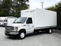 A 2021 Ford E-450 box truck with a white cargo area and a light gray chassis parked in a lot