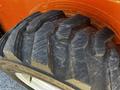 Close-up of a large industrial tire featuring a deep tread pattern designed for traction on various surfaces