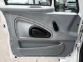 The interior door panel of a 2006 International 4200 featuring a gray textured surface a handle a speaker grille and a smooth armrest design