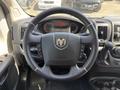 Steering wheel of a 2021 RAM Promaster featuring a central logo and control buttons on the sides