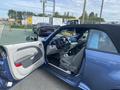 A blue 2007 Chrysler PT Cruiser with a convertible top and an open door revealing a gray interior and dashboard