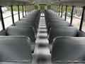 Interior of a 2015 Spartan School Bus featuring rows of gray seats lined along the aisle with large windows on both sides