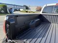The image shows the bed of a 2015 Toyota Tacoma with a black plastic liner and a sidewall storage compartment
