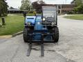 A blue 2020 Genie GTH-5519 telehandler featuring forks in the front and a cab with a large windshield and controls inside