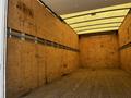 Interior of a 2020 Hino 155 truck showing a spacious cargo area with wooden panel walls and a wooden floor