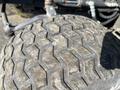 Close-up of a tire from a 2010 Kubota F3990 showcasing a tread pattern with deep grooves and worn areas on the rubber surface