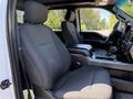 The interior of a 2018 Ford F-150 featuring black fabric seats with a console between them and a modern dashboard design