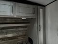 Interior view of a 2022 Heartland Torque with wood paneling and modern cabinetry featuring dark handles