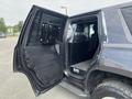A 2016 Chevrolet Tahoe with an open side door featuring a metal grate and a partition in the rear passenger area designed for transporting animals or equipment