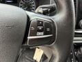 A close-up of the steering wheel controls in a 2023 Ford Transit featuring buttons for cruise control and menu navigation