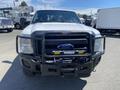 A 2016 Ford F-350 SD in white with a black grill guard and fog lights visible on the front