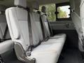 Interior seating of a 2018 Ford Transit van showing gray fabric seats with seatbelts and a spacious layout