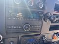 The dashboard of a 2020 Chevrolet Express featuring a radio display with buttons and knobs for controlling audio settings