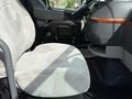 A gray upholstered driver's seat in a 2012 Volvo VNL truck with a padded passenger seat and a wood-accented dashboard visible near the steering wheel