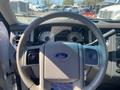 Steering wheel of a 2013 Ford Expedition with a Ford logo and dashboard gauges visible