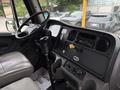 The interior of a 2015 Freightliner M2 106 with a driver's seat dashboard controls and a shifter prominently displayed