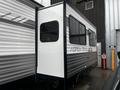 A 2022 Aspen Trail travel trailer with a black and white exterior and a large window on one side