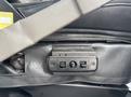 Close-up of the seat adjustment controls for a 2020 Chevrolet Express featuring two buttons and a circular dial mounted on a black leather seat trim